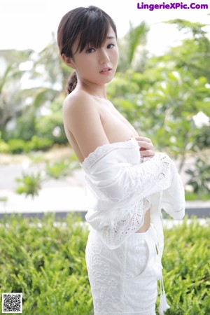 A woman in a white robe sitting on a chair.