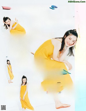 A woman in a pink top and blue jeans posing for a magazine.