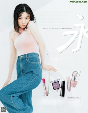 A woman in a pink top and blue jeans posing for a magazine.