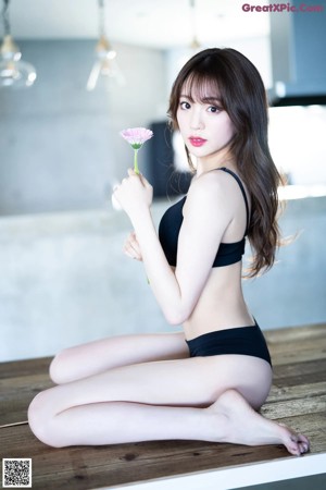 A woman in a blue lingerie standing in a bedroom.