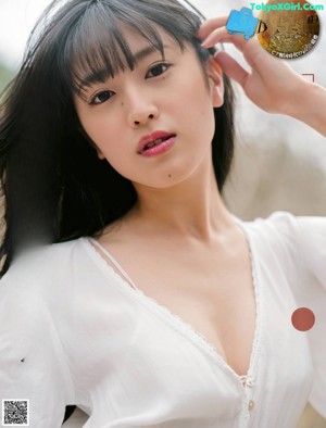 A woman in a white dress standing in a field.