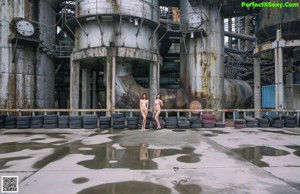A naked woman standing in a dark room.