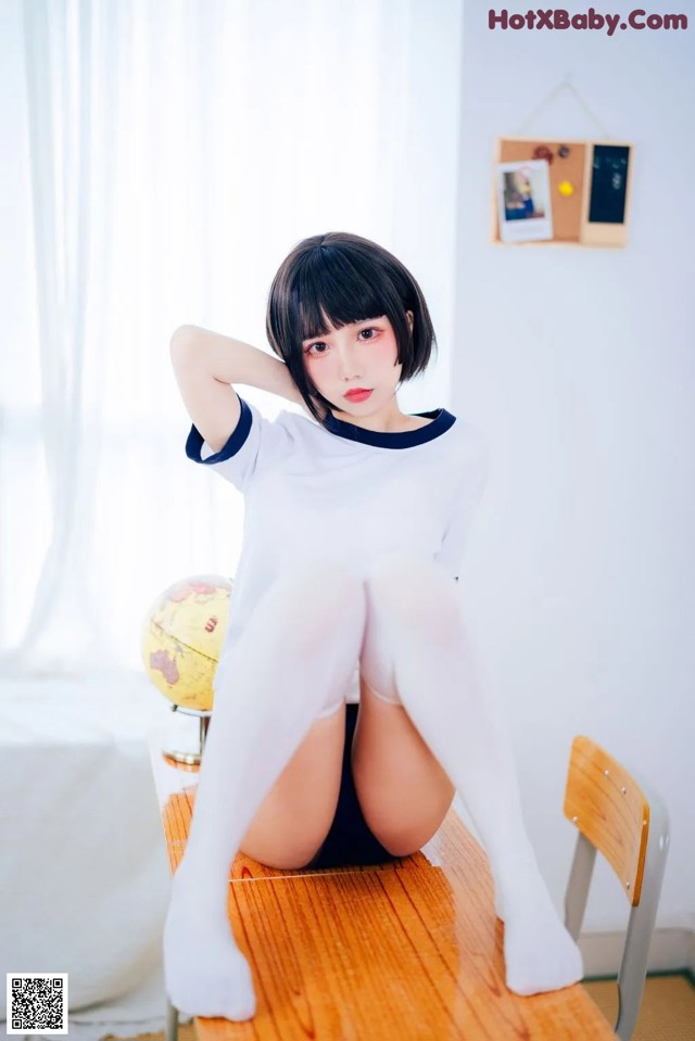 A woman sitting on top of a wooden table.