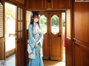 A woman in a kimono sitting under an umbrella.