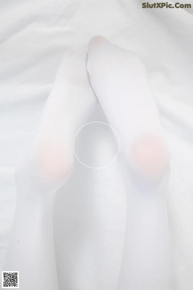 A pair of white stockings on a bed.