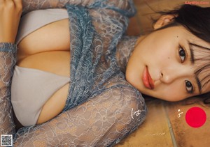 A woman in a red lingerie sitting on a kitchen counter.