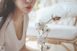 A woman sitting on a chair holding a toy fish.