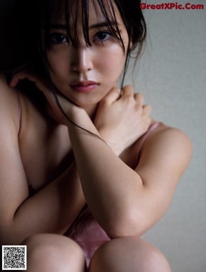 A woman in a white shirt is posing for a magazine.