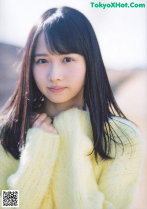 A woman with long black hair and bangs is looking at the camera.