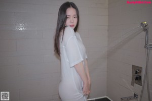 A woman sitting on a toilet in a bathroom.