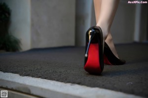 A woman in a black suit sitting on a set of stairs.