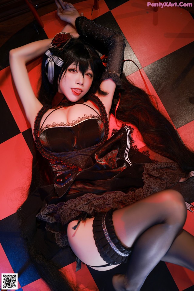 A woman with long black hair laying on a checkered floor.