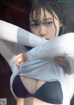 A woman in a white shirt and blue panties posing for a magazine.