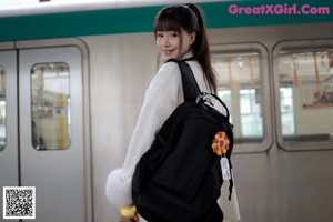 A woman in a school uniform is posing for the camera.