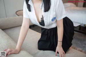 A woman in stockings and high heels is sitting on a couch.