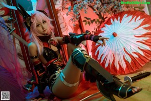 A woman with pink hair is sitting on the floor.