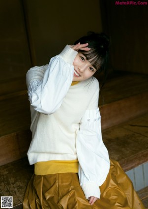 A woman in a purple kimono sitting on a wooden floor.
