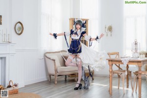 A woman in a maid outfit is sitting on a couch.